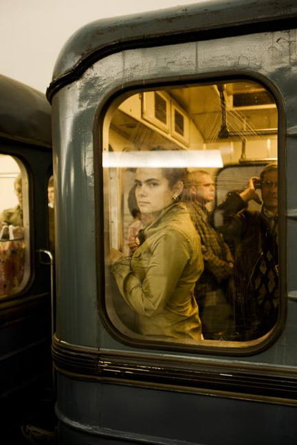 Woman Looking Through The Window Of A Subway Car, Moscow, Russia.